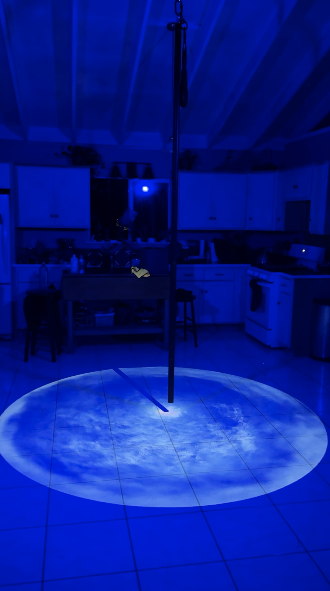 A projected pool of blue light beneath an aerial apparatus